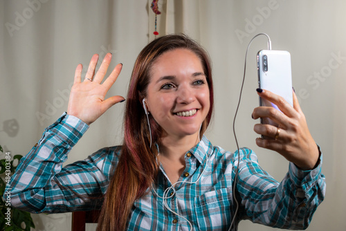 Mujer teniendo una tele llamada con su celular photo