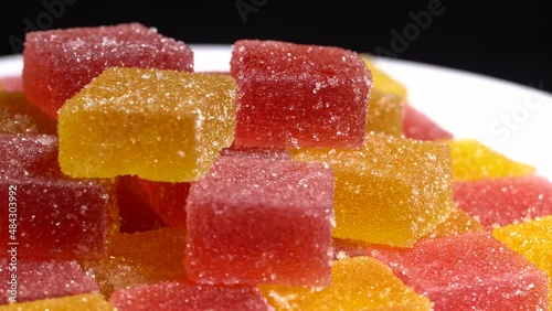 Red and orange marmalade with sugar, rotation background. Close up