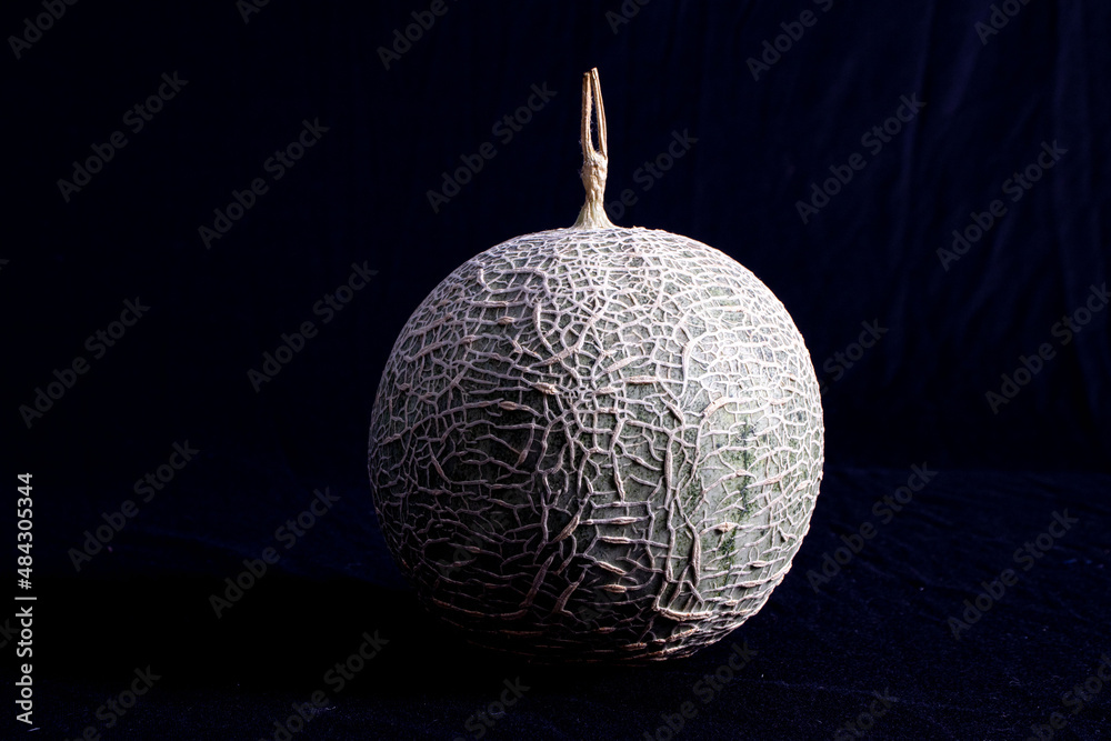 Photo of full organic melon from your own garden with a black background Photo of full organic melon from your own garden with a black background