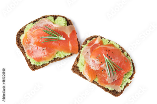 Delicious sandwiches with salmon, avocado and rosemary on white background, top view