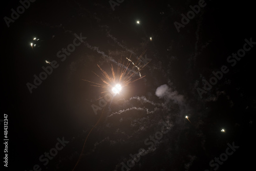 Fireworks flash in the cold frosty sky. Festive background with copy space. Fireworks and sparks from it in the cold. Fireworks and crackers for a holiday at events. Soft focus, light from fireworks