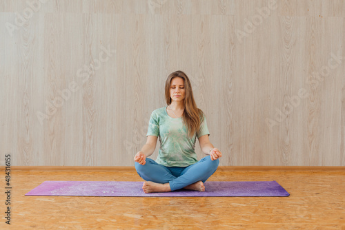 Young caucasian woman doing yoga asanas at home.