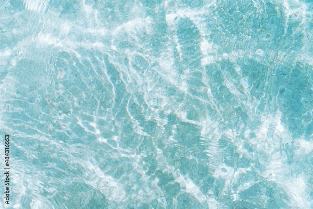 Obraz premium Small waves in the pool reflect the glare of the sun