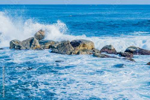 Ocean waves crashing against huge boulders