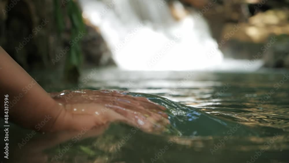 Hand scooping fresh stream waterfall in the forest, Slow motion of clean water in human hands, water resources, earth, environment, conservation.