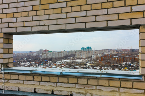 window in a brick wall, roof of a house overlooking the city, brickwork