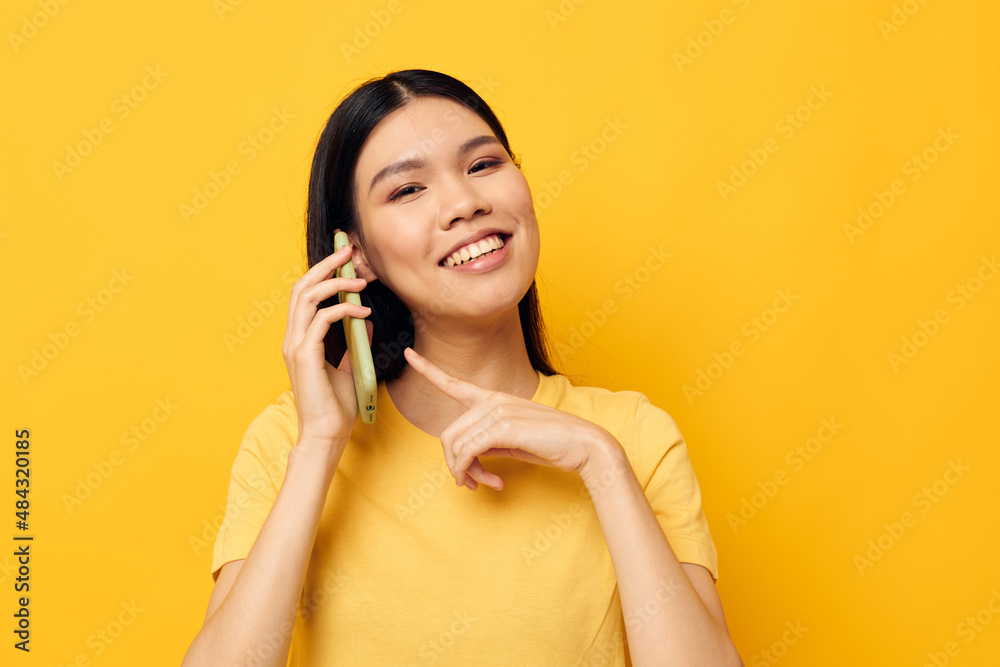 pretty brunette talking on the phone posing technology yellow background unaltered