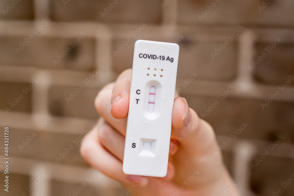 Hands holding Covid-19 rapid antigen test cassette with positive result of rapid diagnostic test Hands holding Covid-19 rapid antigen test cassette with positive result of rapid diagnostic test