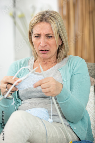 distressed woman noticing a knitting mistake