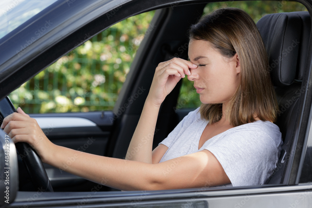 stressed woman having headache while driving car