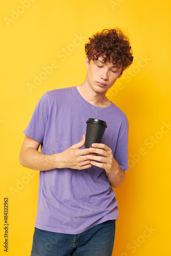 guy with curly hair disposable black glasses yellow background © Tatiana