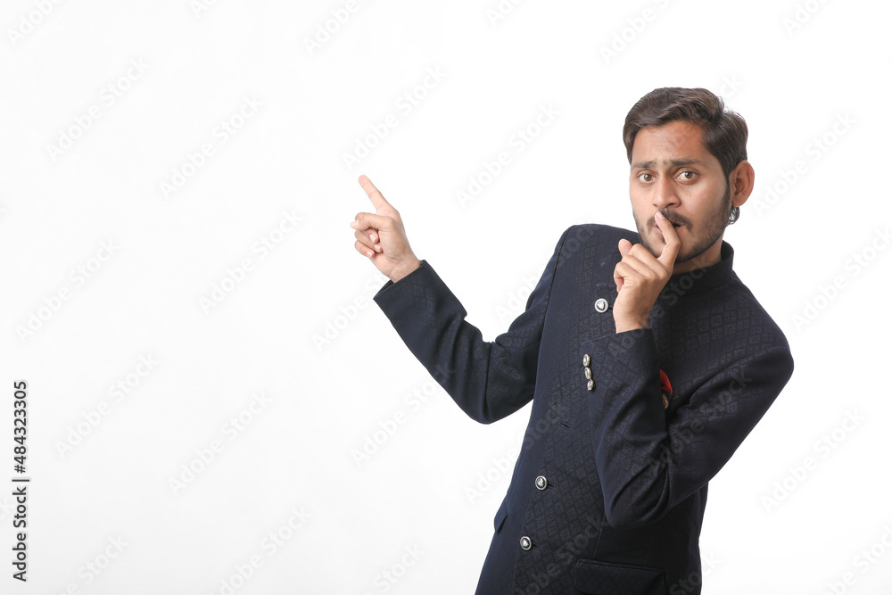 young indian man in traditional wear and giving expression on white background. young indian man in traditional wear and giving expression on white background.