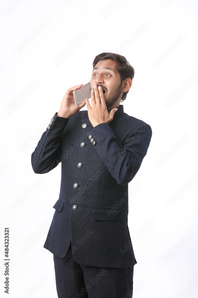 Young indian man talking on mobile phone over white background. Young indian man talking on mobile phone over white background.