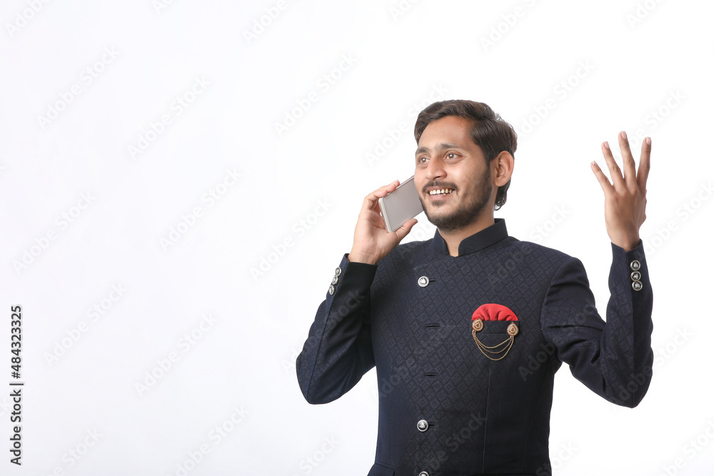 Young indian man talking on mobile phone over white background. Young indian man talking on mobile phone over white background.
