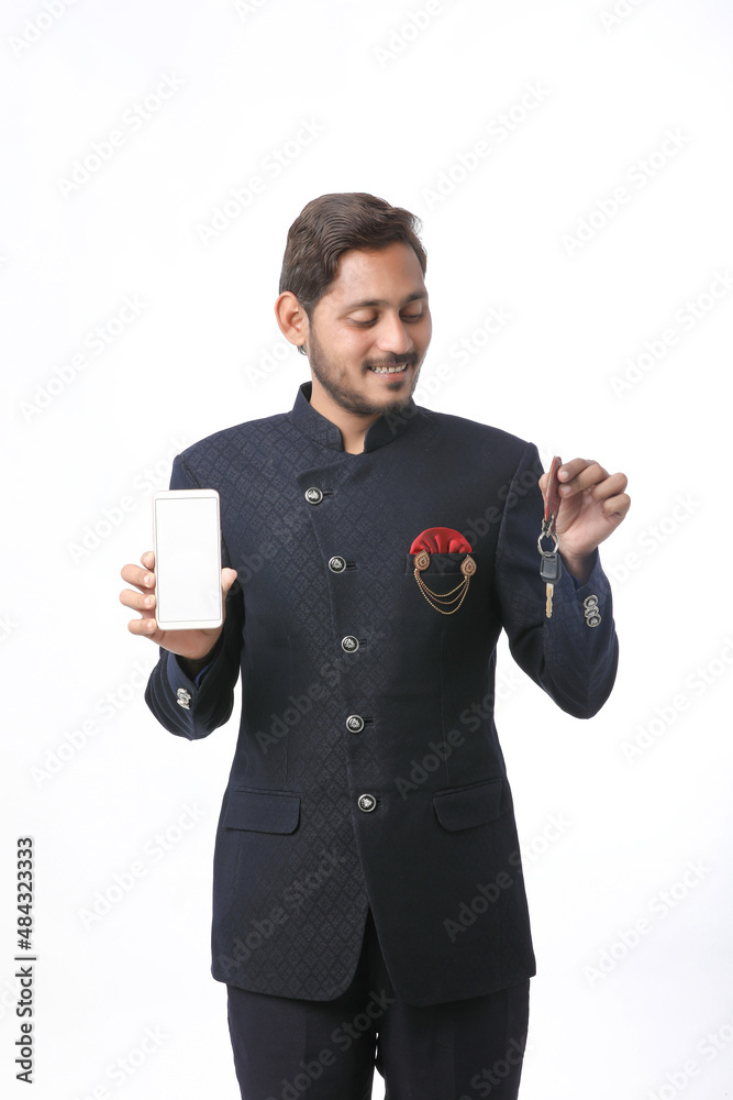 Young indian man in tradition wear and showing smartphone screen on white background. Young indian man in tradition wear and showing smartphone screen on white background.