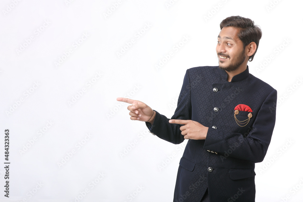 young indian man in traditional wear and giving expression on white background. young indian man in traditional wear and giving expression on white background.