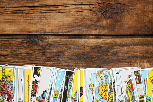 Tarot cards on wooden table, top view. Space for text photo