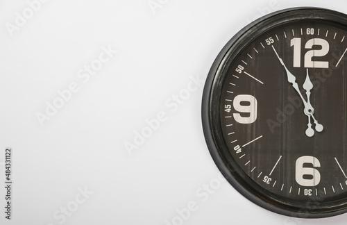 Stylish analog clock hanging on white wall, space for text. New Year countdown
