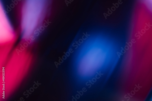Blur glow overlay. Neon flash light. Ultraviolet radiance flare filter. Defocused uv led pink purple blue color flecks on dark black abstract background.