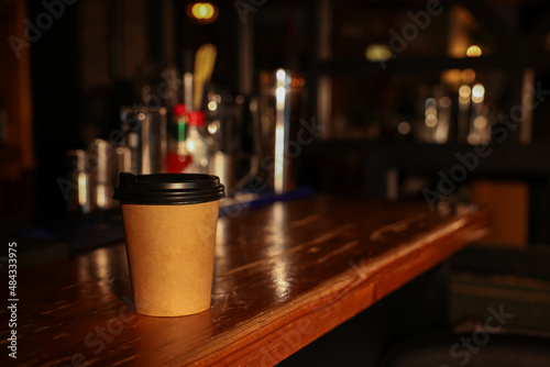 Paper coffee cup on wooden table in cafe. Space for text © New Africa