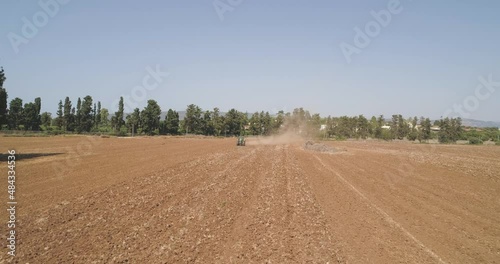 Kibbutz, Israel - 25 November 2021: Aerial view of a tractor ploughing an empty field, Kibbutz saar, Israel.