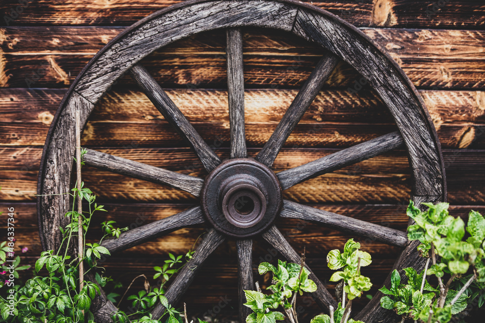 Garden landscaping with a wooden spokewheel and a picket fence