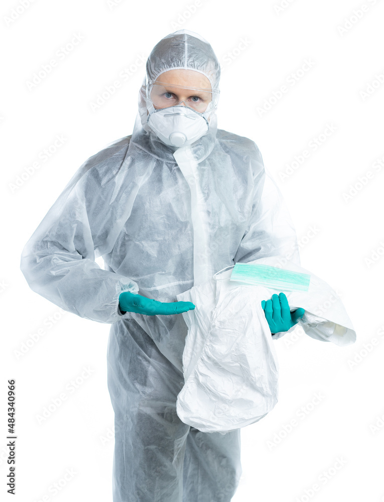 Fototapeta premium a man in a white suit, mask and glasses, holds a protective kit, the doctor looks at us and offers to wear styly clothes. virologist specialist. individual protection of a person. isolated