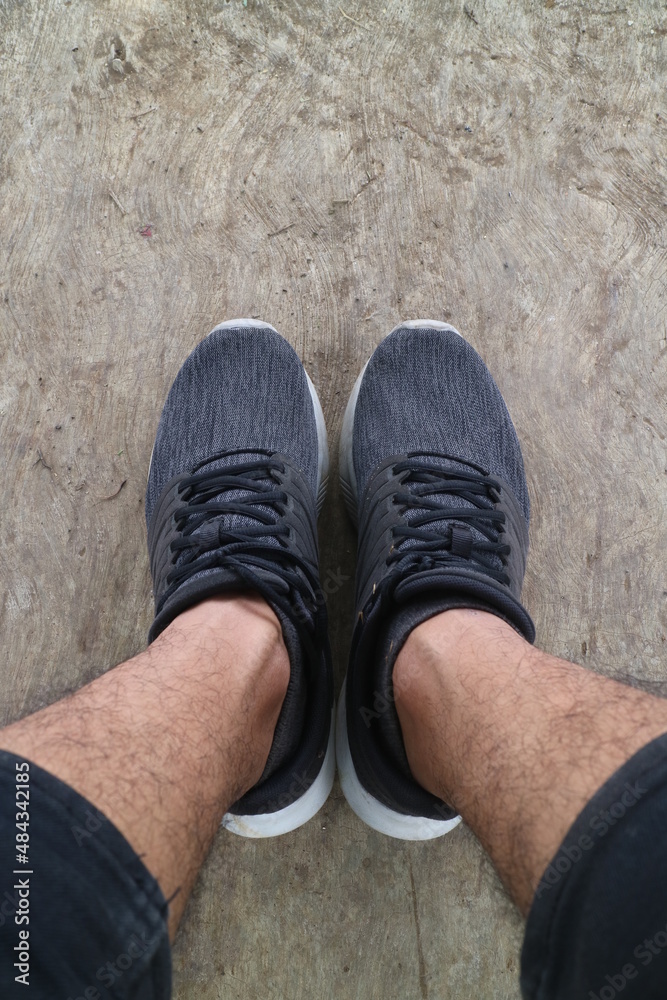 feet of man wearing black shoes