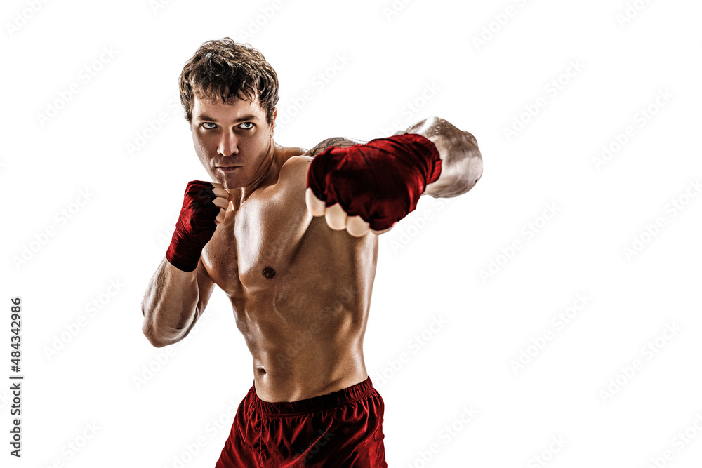 Studio shot of aggressive boxer who training, practicing swing on white background. Red sportswear