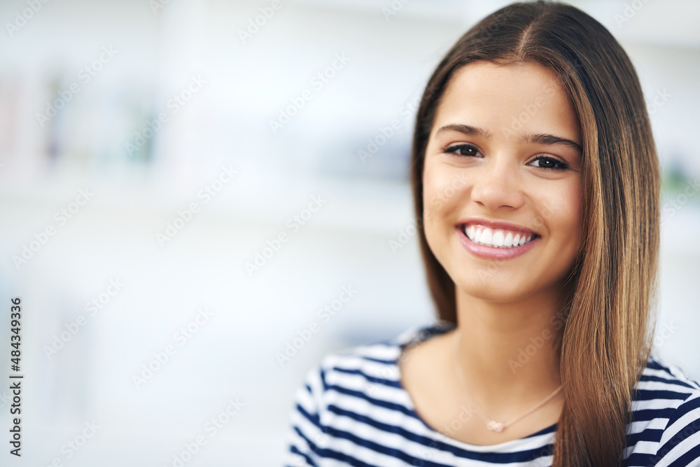 She has the perfect smile. Portrait of an attractive young woman smiling and relaxing at home.