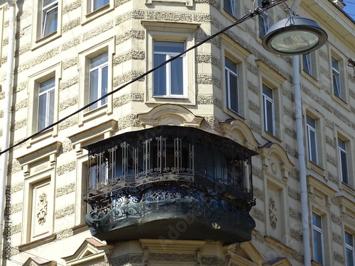 Fragment of the facade of an old house with a metal vintage balcony 