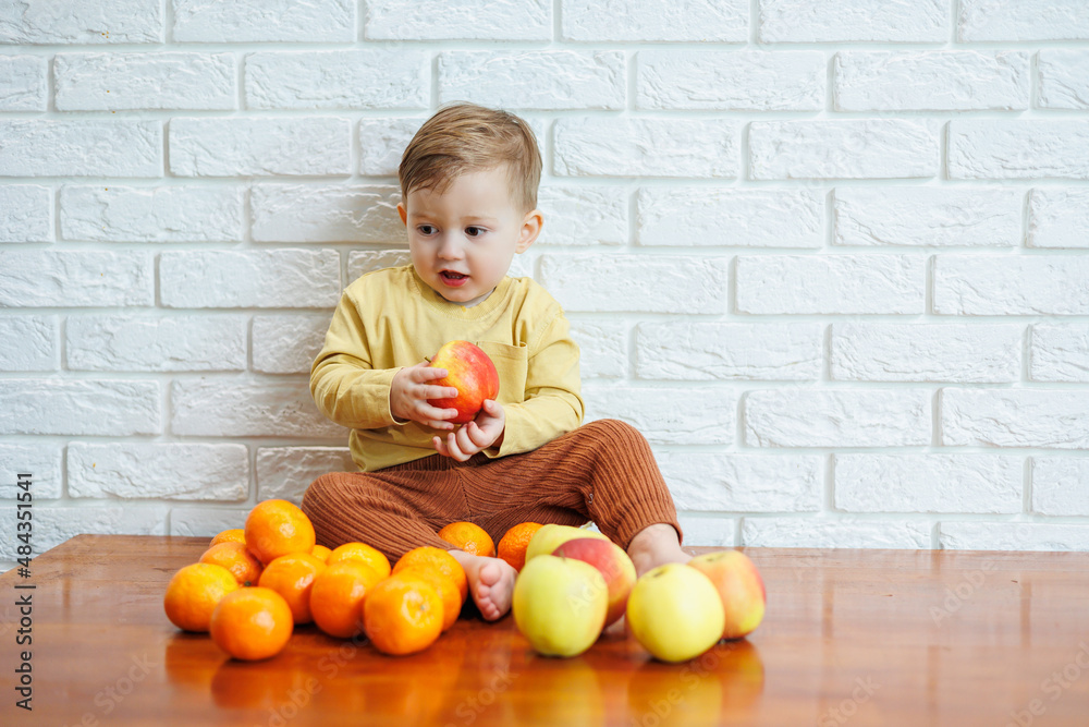 Cute smiling kid eating one fresh juicy red apple. Healthy fruits for young children Cute smiling kid eating one fresh juicy red apple. Healthy fruits for young children