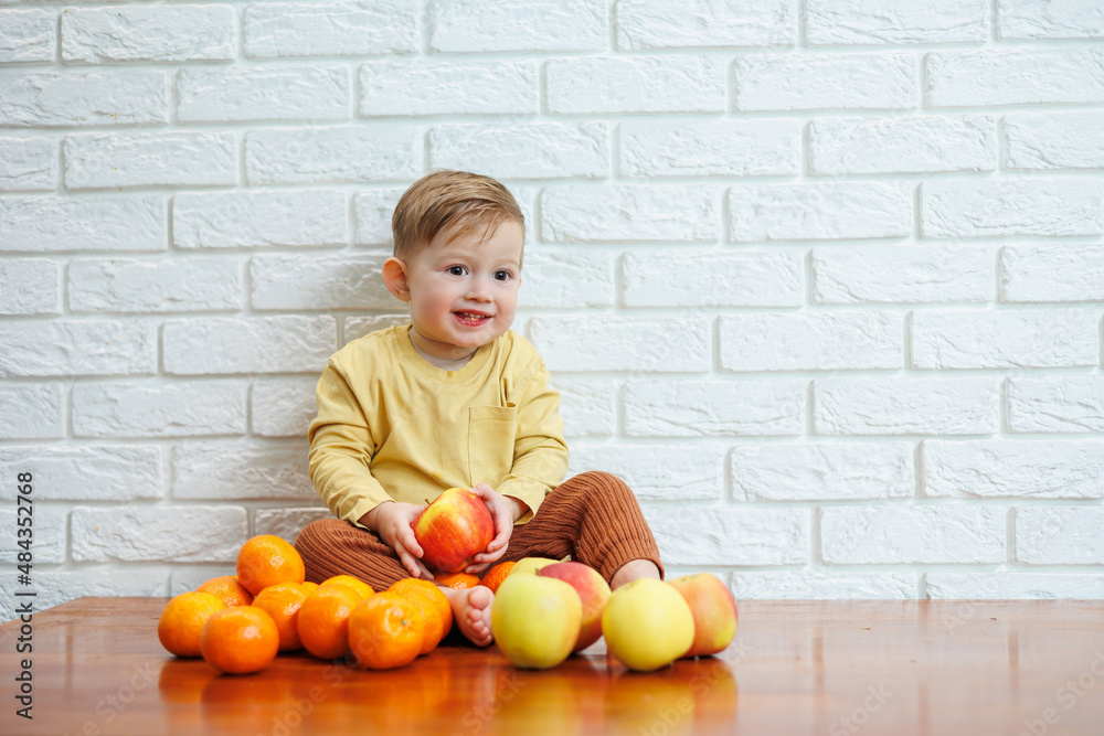 Cute smiling kid eating one fresh juicy red apple. Healthy fruits for young children Cute smiling kid eating one fresh juicy red apple. Healthy fruits for young children