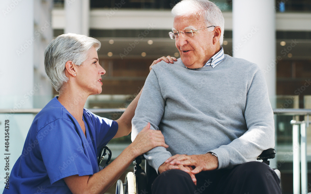 Fototapeta premium How are you feeling today. Cropped shot of a senior man sitting in a wheelchair while his attractive mature nurse aid assists him indoors.