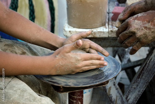 The master teaches pottery. The hands of a potter and a child. Education concept.