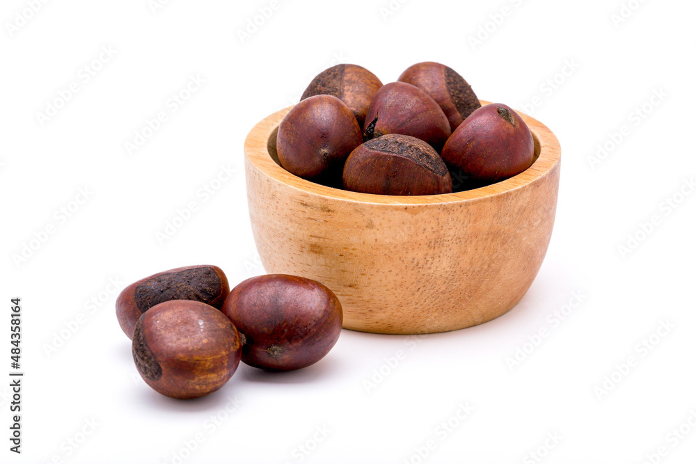 Group of roasted chestnuts on a wooden bowl and in front off bowl isolated on a white background. Group of roasted chestnuts on a wooden bowl and in front off bowl isolated on a white background.