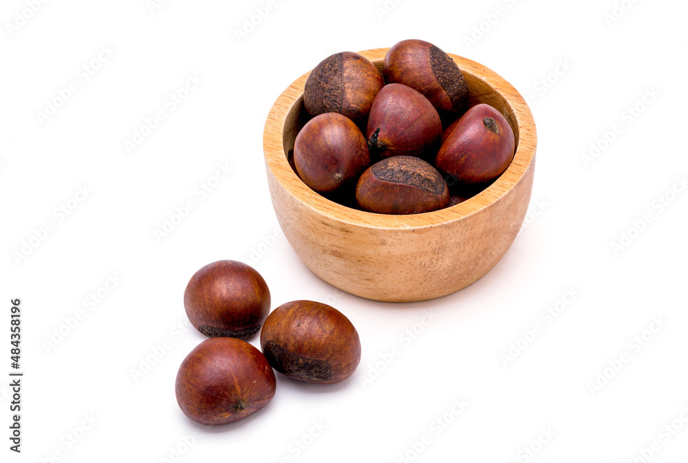 Group of roasted chestnuts on a wooden bowl and in front off bowl isolated on a white background. Group of roasted chestnuts on a wooden bowl and in front off bowl isolated on a white background.