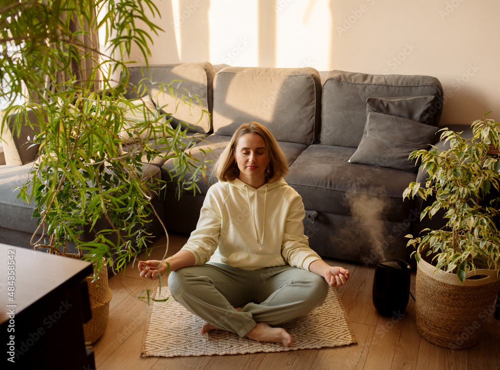 Young woman doing yoga medications exercises and watching lessons online on the smartphone at home. Young woman doing yoga medications exercises and watching lessons online on the smartphone at home.