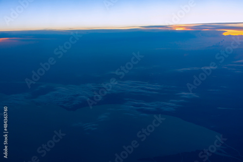 Clouds sunset plane. Aerial view of the orange-blue evening light from the airplane window. Panorama cloud landscape stratosphere. The concept of freedom and independence of travel. Sky background