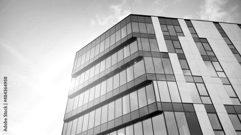 Modern glass and aluminum wall of office building outdoor with bright sun rays falling. Black and white. Modern glass and aluminum wall of office building outdoor with bright sun rays falling. Black and white.