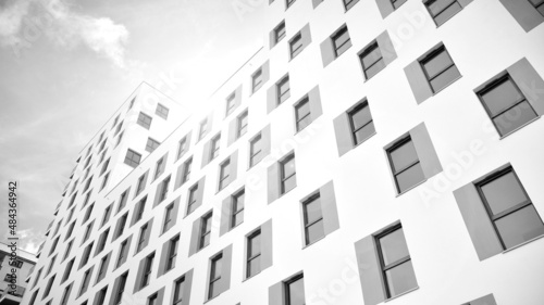 Modern luxury residential flat. Modern apartment building on a sunny day. White apartment building with a blue sky. Facade of a modern apartment building. Black and white.