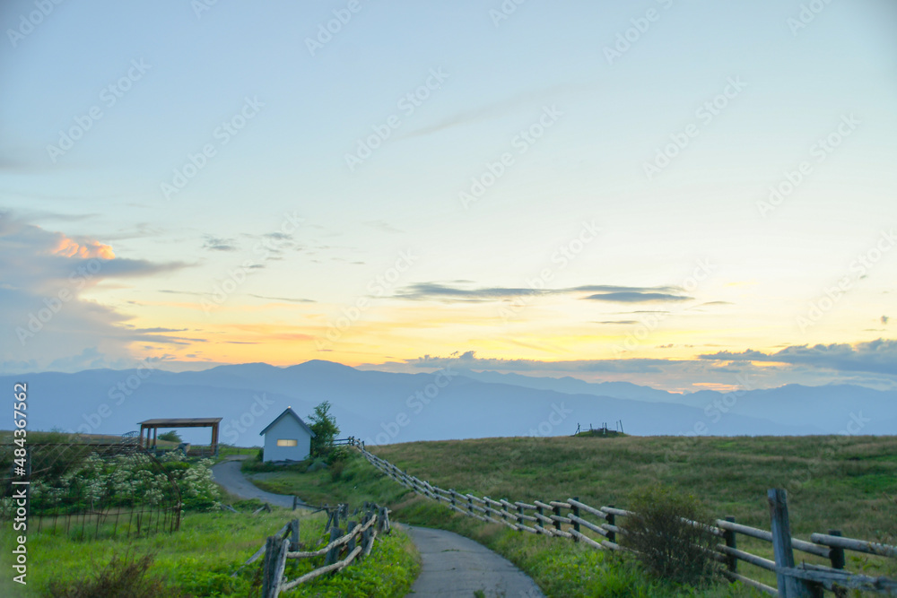 A lonely log cabin sit silently on the hill and the dusk settled over the mountain in summer Japan.