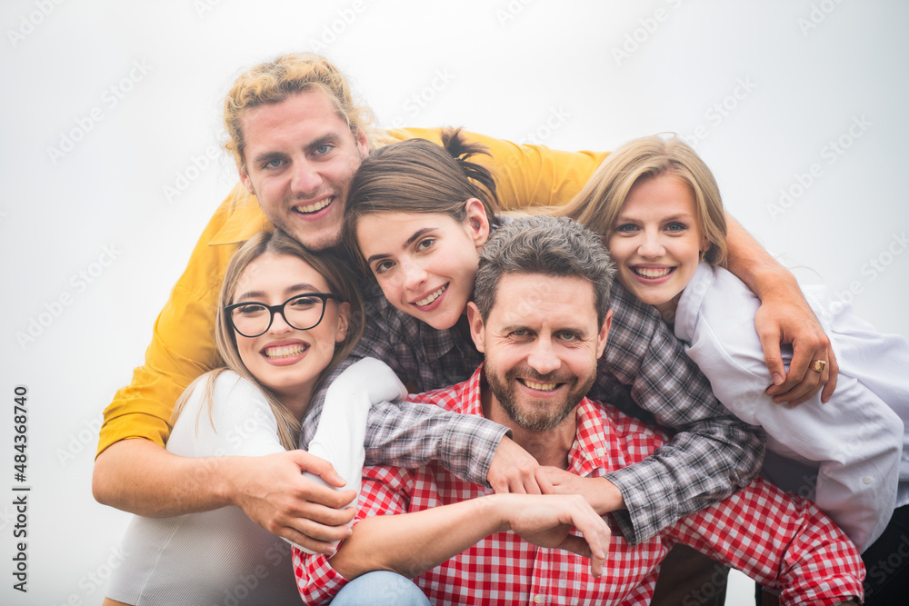 Smiling group of friends laughing. Group of friends embrace together outdoors. Cheerful multiracial people laughing together, happy diverse young employees students group team having fun, human Smiling group of friends laughing. Group of friends embrace together outdoors. Cheerful multiracial people laughing together, happy diverse young employees students group team having fun, human