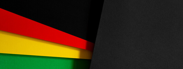 Black History Month color background. African American history month celebration. Abstract red, yellow, green color flag on black paper background