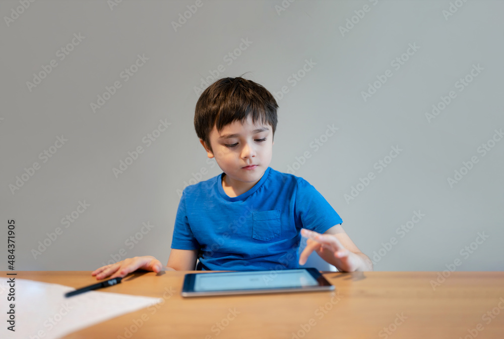 School Kid learning online class room at home, Child using tablet for homework, Young boy studying online video call, E-learning or Homeschooling education concept School Kid learning online class room at home, Child using tablet for homework, Young boy studying online video call, E-learning or Homeschooling education concept