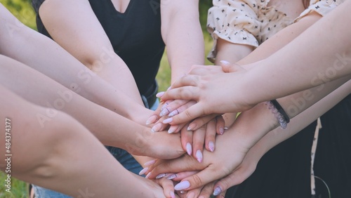 Group of female hands together in the park.