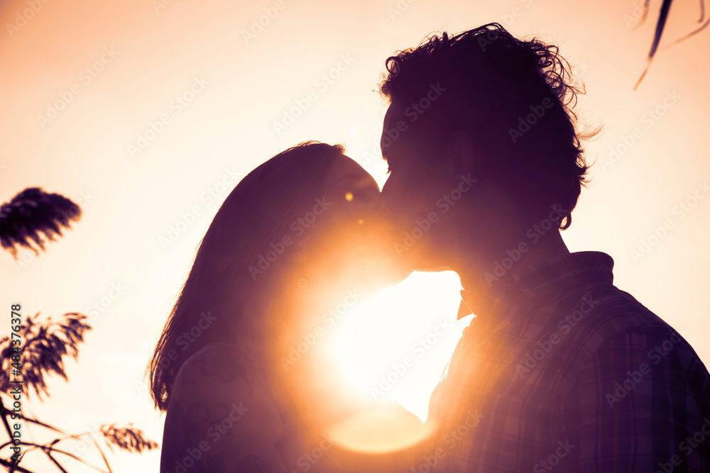 Hombre y mujer besándose en la puesta de sol. Romanticismo.
