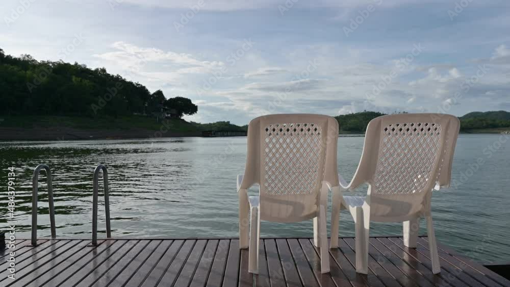 Two chairs sitting on balcony and facing on lake Two chairs sitting on balcony and facing on lake