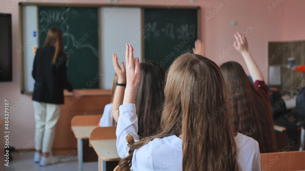 High school students stretch their hands in the lesson. Russian school. High school students stretch their hands in the lesson. Russian school.
