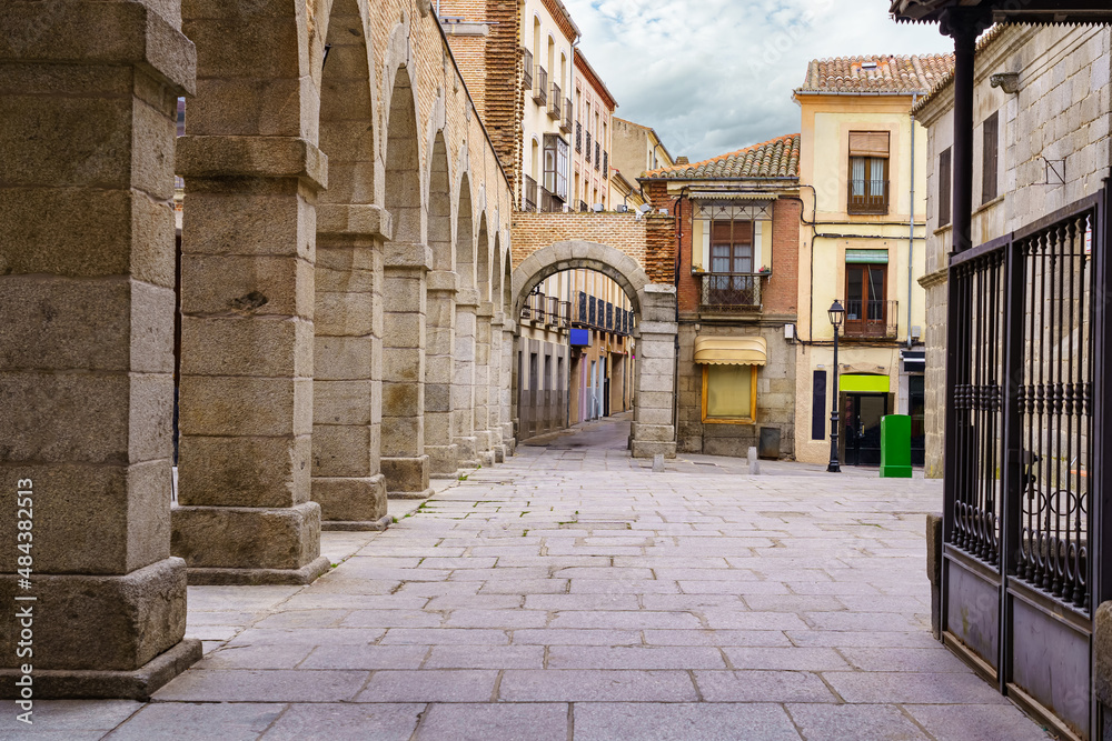 Obraz premium Street and square with stone arches and old houses in the city of Avila, Spain.